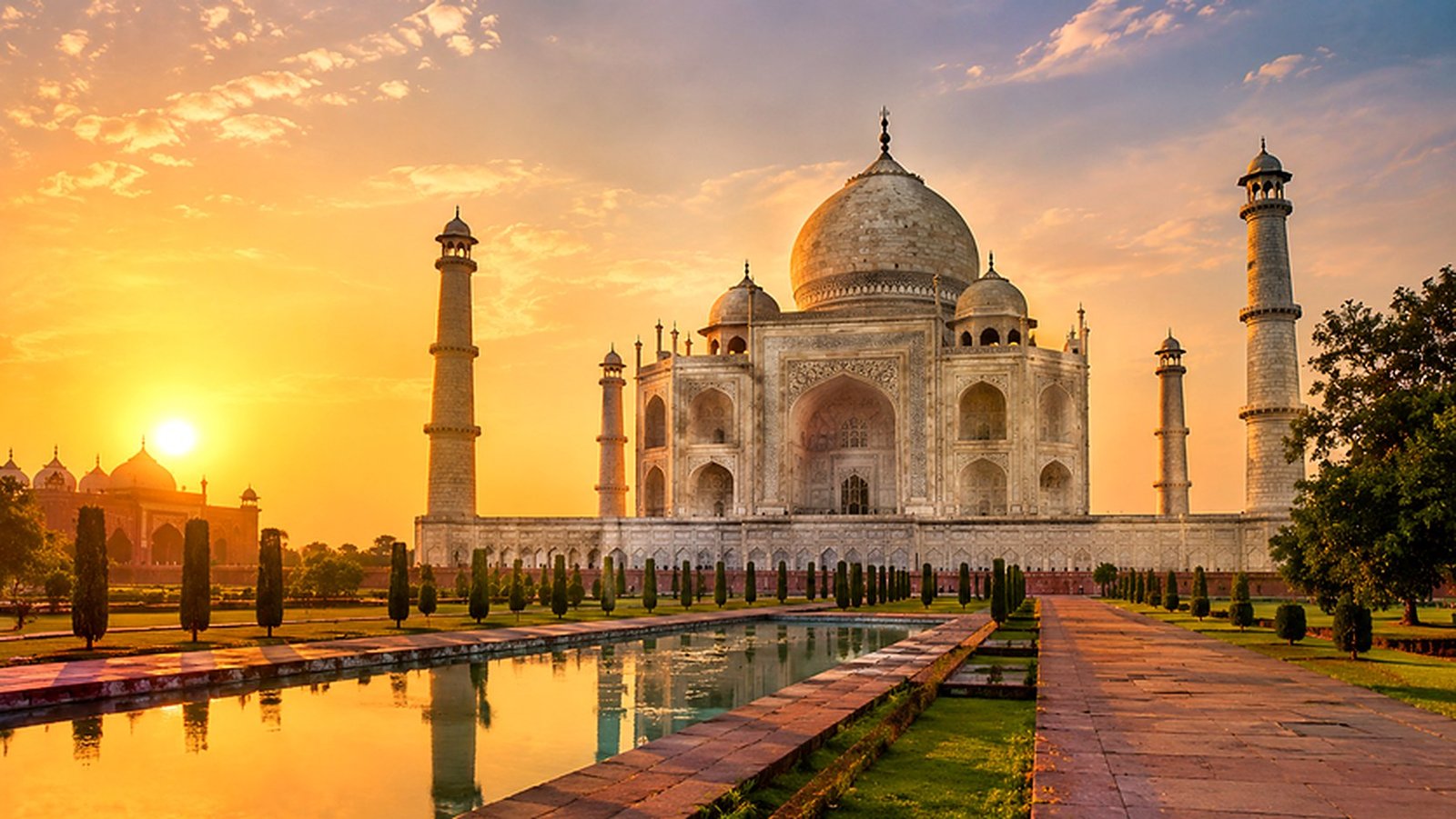 Taj Mahal ao nascer do sol, refletido no espelho d'água, em Agra, Índia
